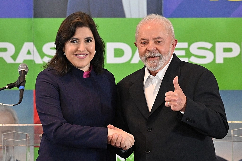 Brazil's former President (2003-2010) and presidential candidate for the leftist Workers Party (PT), Luiz Inacio Lula da Silva (R), shakes hands with former presidential candidate Simone Tebet (MDB), after a meeting in Sao Paulo, Brazil, on October 7, 2022. (Photo by NELSON ALMEIDA / AFP)